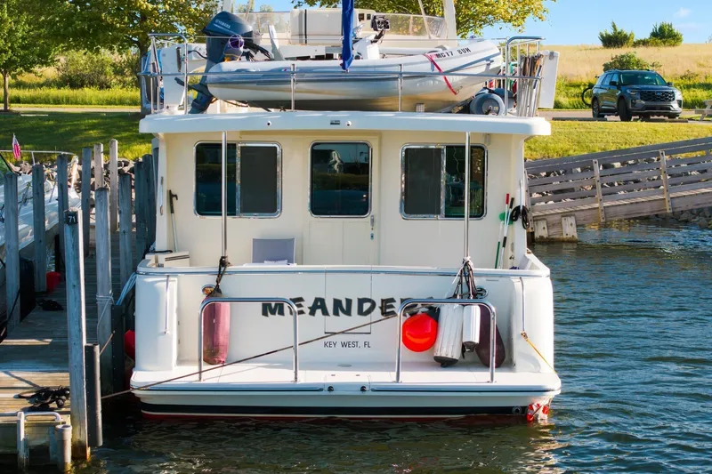 Slide: The Image of Rear view of 2015 North Pacific NP49 boat docked, with dinghy on top. - 53
