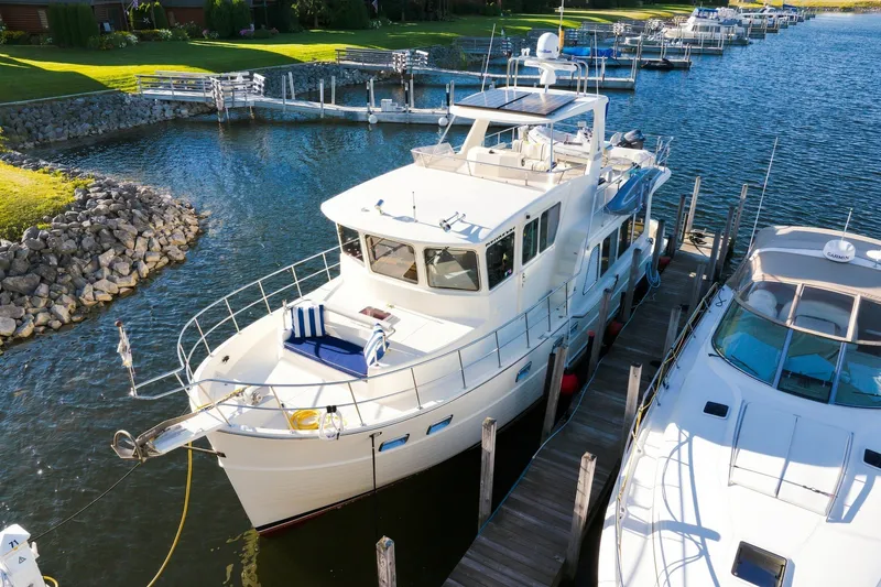 Slide: The Image of 2015 North Pacific NP49 yacht docked at a marina, surrounded by calm water and greenery. - 3