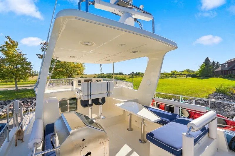 Slide: The Image of 2015 North Pacific NP49 yacht deck with seating, surrounded by lush greenery and blue skies. - 38