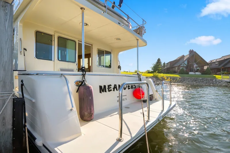 Slide: The Image of 2015 North Pacific NP49 yacht docked by waterfront homes under clear blue sky. - 54