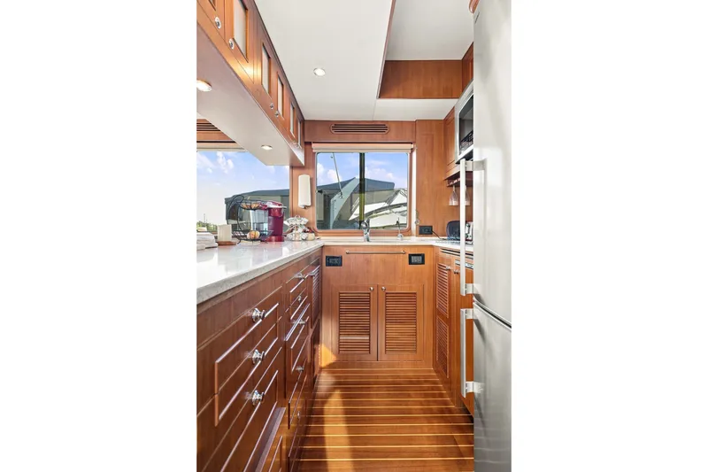 Slide: The Image of Luxurious 2015 North Pacific NP49 yacht kitchen with wooden cabinetry and modern appliances. - 12