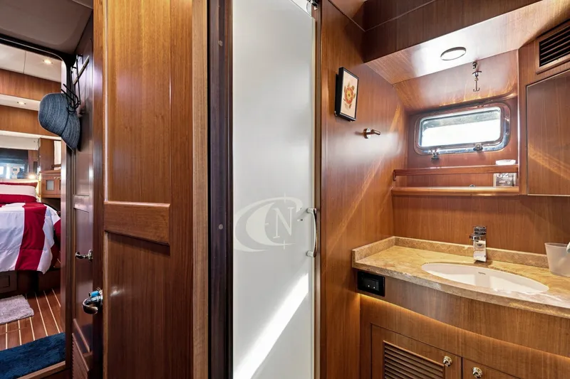 Slide: The Image of Luxurious 2015 North Pacific NP49 yacht interior with wood finish, featuring a cozy bedroom and bathroom. - 32