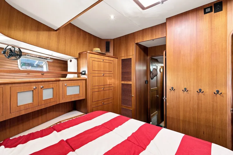 Slide: The Image of Cozy cabin interior of 2015 North Pacific NP49 yacht with wooden furnishings and striped bedding. - 24