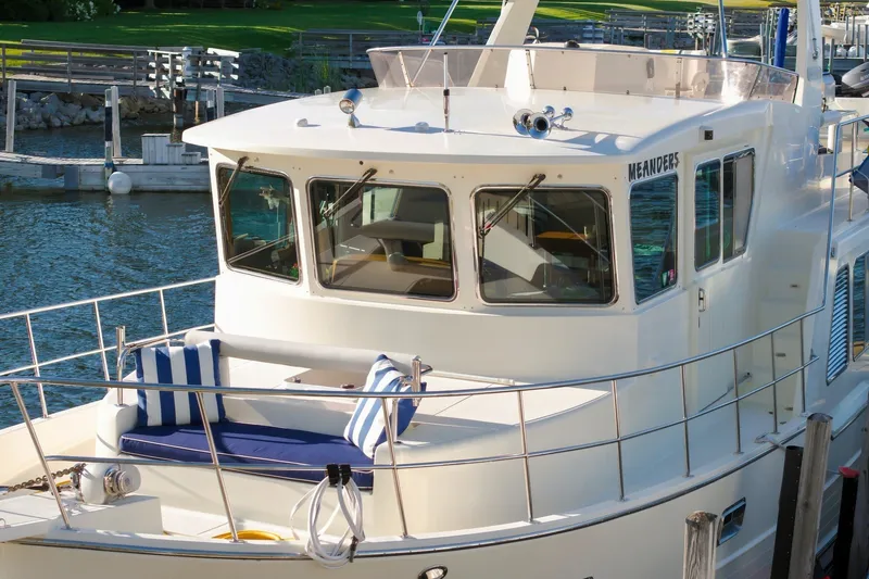 Slide: The Image of 2015 North Pacific NP49 yacht docked, featuring a spacious deck with striped cushions. - 51