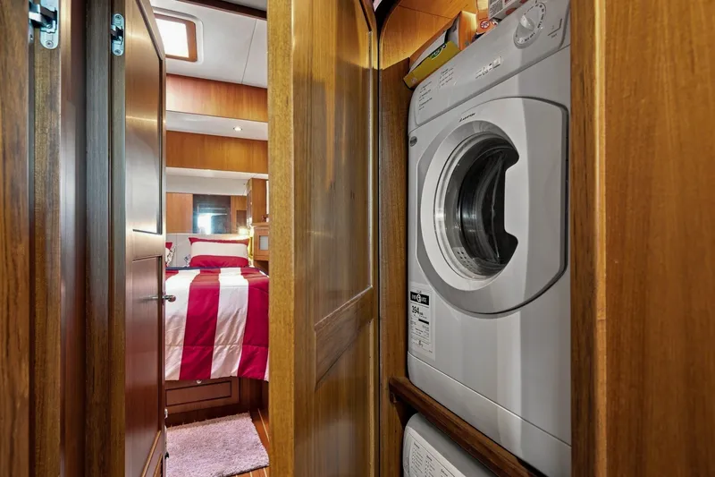 Slide: The Image of Laundry area in 2015 North Pacific NP49 yacht, featuring a washing machine and cozy bedroom. - 34
