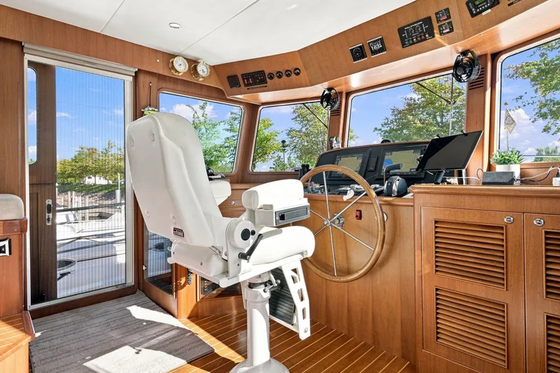 Slide: The Image of Pilothouse interior of 2015 North Pacific NP49 yacht with helm, controls, and captain's chair. - 16