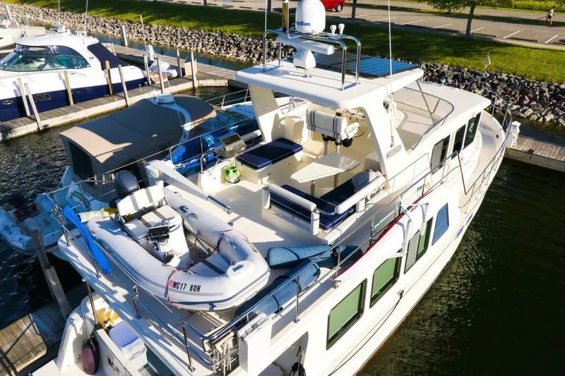Slide: The Image of 2015 North Pacific NP49 yacht docked, featuring spacious deck and inflatable boat. - 47