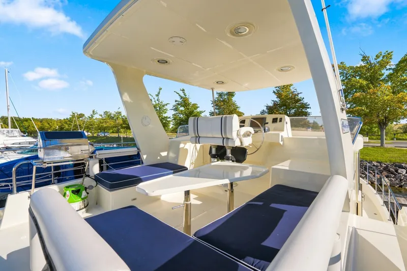Slide: The Image of Luxurious 2015 North Pacific NP49 yacht deck with seating and helm, docked by trees. - 36