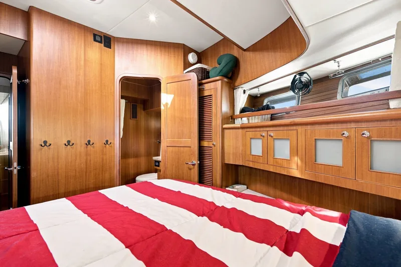 Slide: The Image of Luxurious cabin interior of 2015 North Pacific NP49 yacht with wooden finishes and striped bedding. - 23