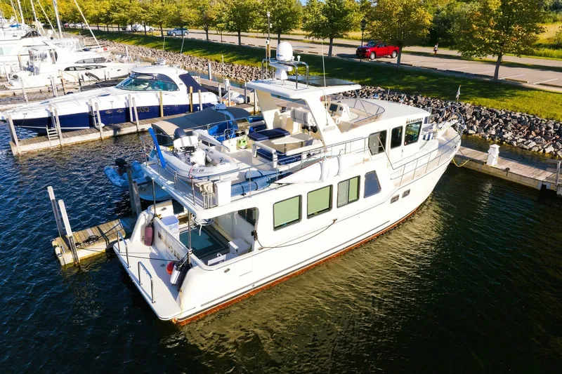 Slide: The Image of 2015 North Pacific NP49 yacht docked at marina, surrounded by other boats and greenery. - 60