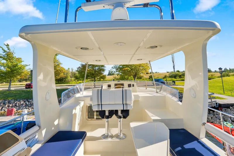 Slide: The Image of 2015 North Pacific NP49 yacht deck with seating, surrounded by lush greenery and blue skies. - 37