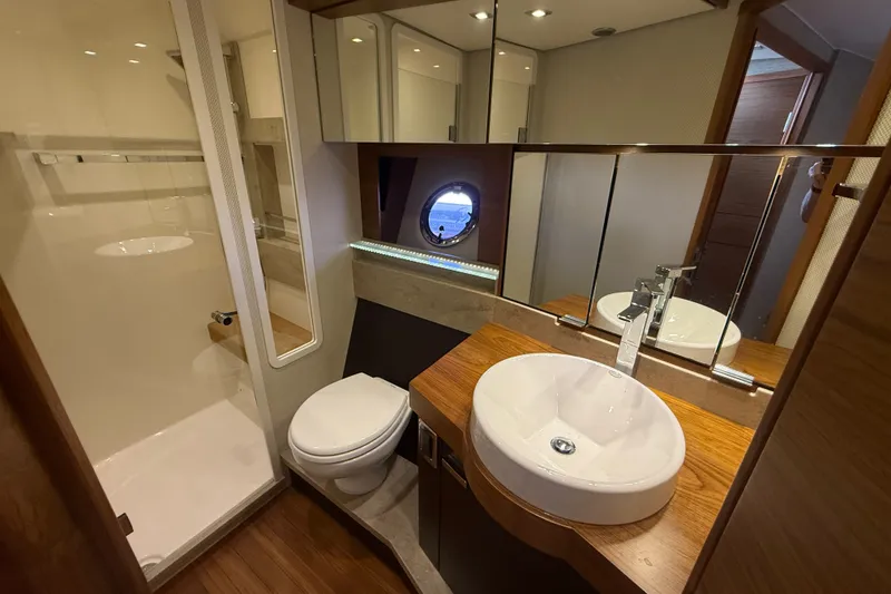 Slide: The Image of Luxurious bathroom in 2015 Tiara Yachts C44 Coupe with modern fixtures and wood accents. - 18