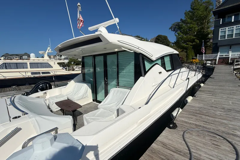 Slide: The Image of 2015 Tiara Yachts C44 Coupe docked, showcasing sleek design and spacious deck area. - 3