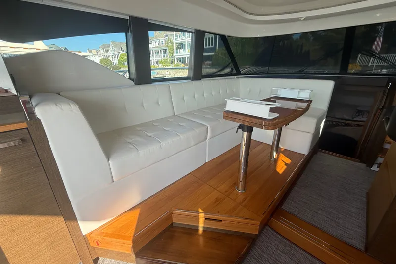 Slide: The Image of Interior of 2015 Tiara Yachts C44 Coupe with white seating and wooden table. - 41