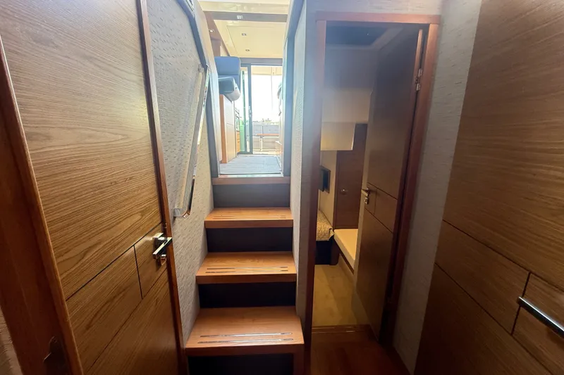 Slide: The Image of Interior view of 2015 Tiara Yachts C44 Coupe, featuring wooden stairs and cabin access. - 24