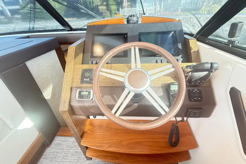 Slide: The Image of Helm of 2015 Tiara Yachts C44 Coupe with steering wheel and navigation controls. - 36