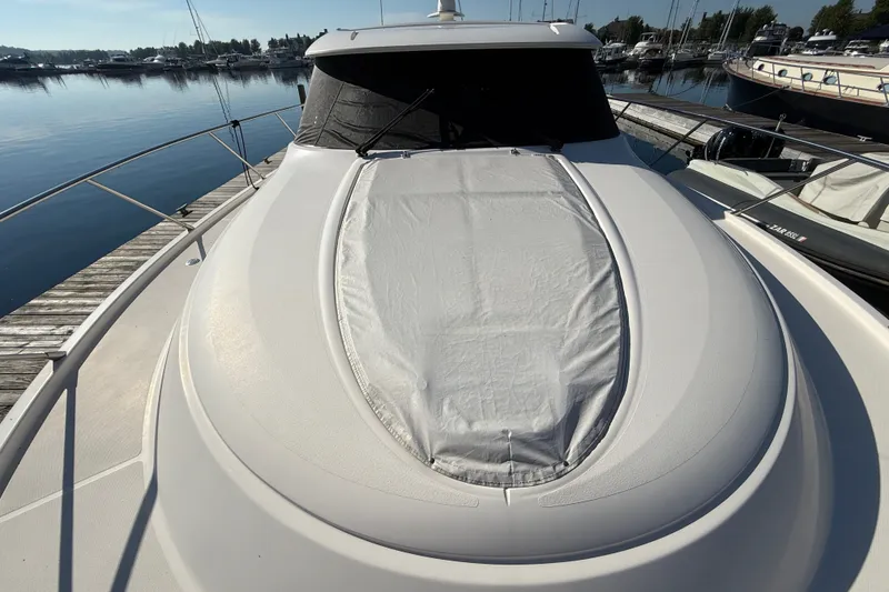 Slide: The Image of 2015 Tiara Yachts C44 Coupe docked at marina, showcasing sleek design and covered deck. - 43
