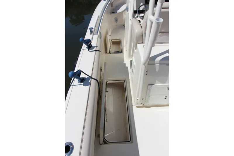 Slide: The Image of 2015 Cobia 296 Center Console boat deck with storage compartments and rod holders. - 22