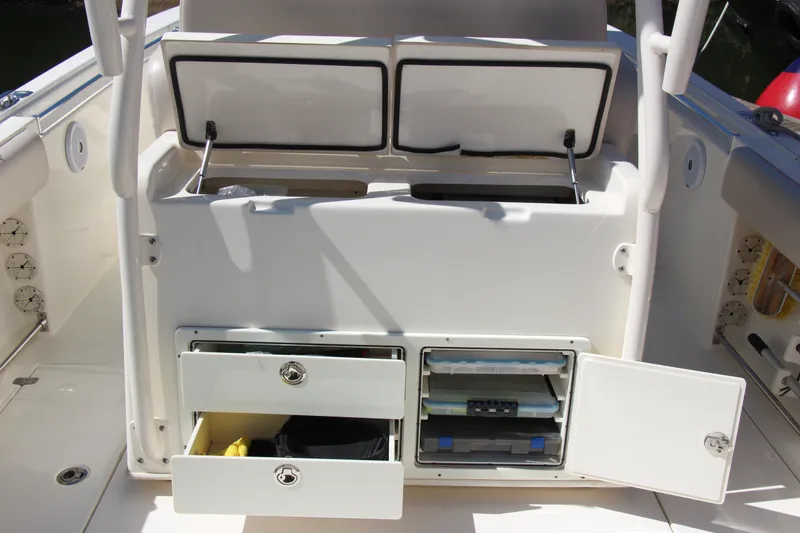 Slide: The Image of 2015 Cobia 296 Center Console boat storage compartments with open drawers and cabinets. - 21