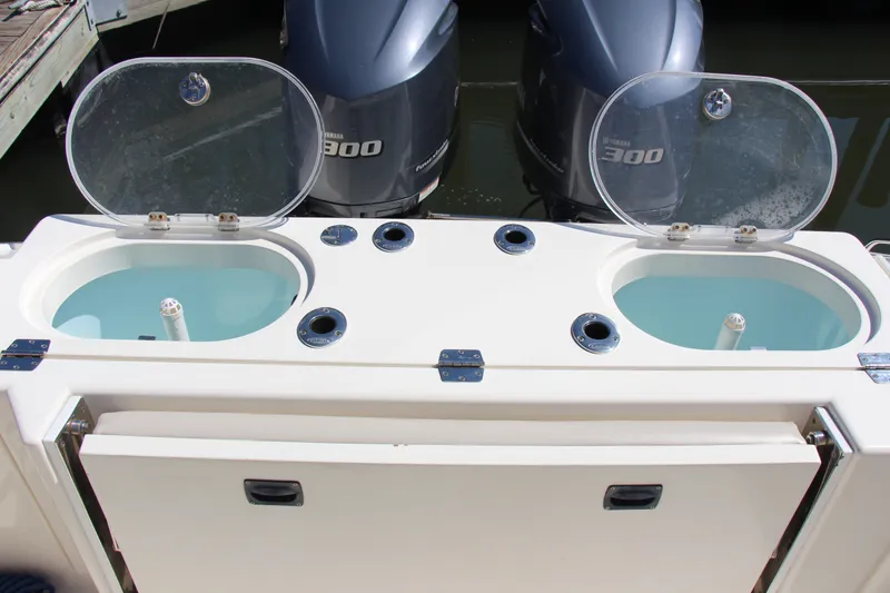 Slide: The Image of 2015 Cobia 296 Center Console boat with dual Yamaha 300 engines and open livewells. - 20