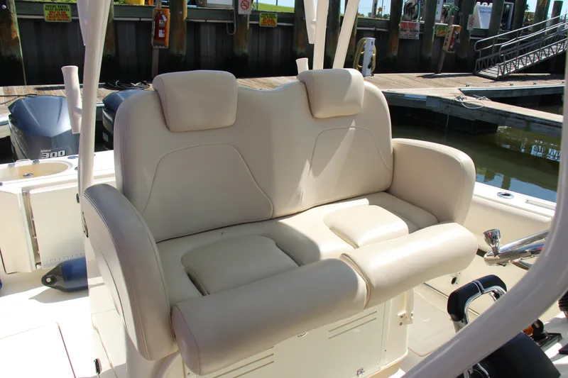 Slide: The Image of 2015 Cobia 296 Center Console boat with beige cushioned seating at the dock. - 17