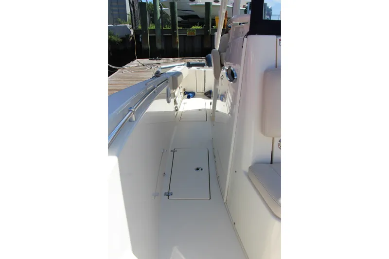 Slide: The Image of 2015 Cobia 296 Center Console boat interior, featuring sleek white deck and seating. - 14