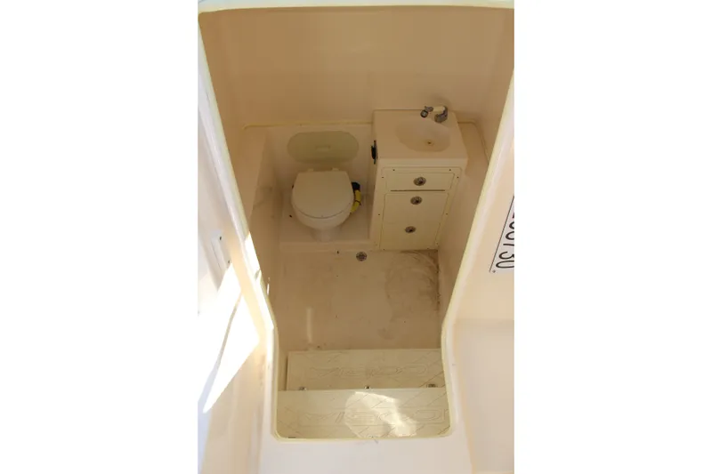 Slide: The Image of 2015 Cobia 296 Center Console boat interior with toilet and sink. - 15