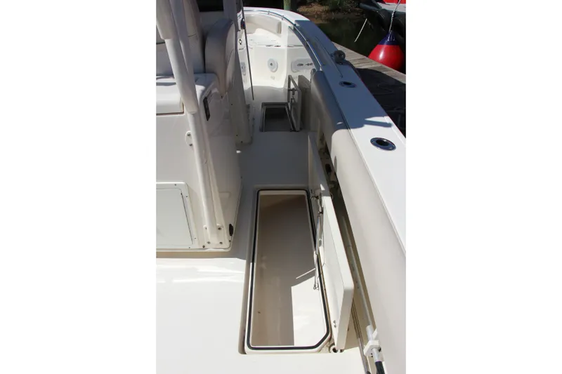 Slide: The Image of 2015 Cobia 296 Center Console boat deck with open storage compartment. - 23