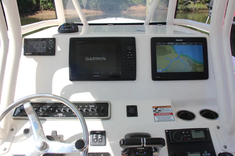 Slide: The Image of 2015 Cobia 296 Center Console dashboard with Garmin and Raymarine navigation displays. - 25