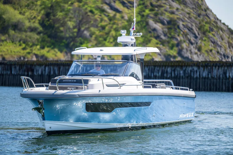 Slide: The Image of 2023 Nimbus Tender 11 boat cruising on a sunny day near rocky shoreline. - 10