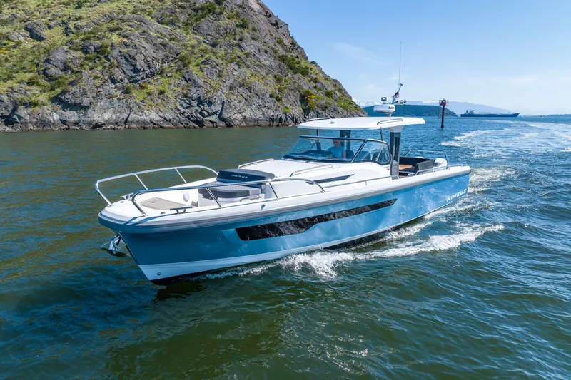 Slide: The Image of 2023 Nimbus Tender 11 cruising near rocky shoreline on a sunny day. - 18
