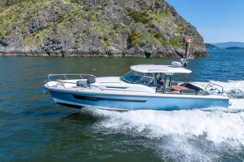 Slide: The Image of 2023 Nimbus Tender 11 cruising near rocky coastline on a sunny day. - 16