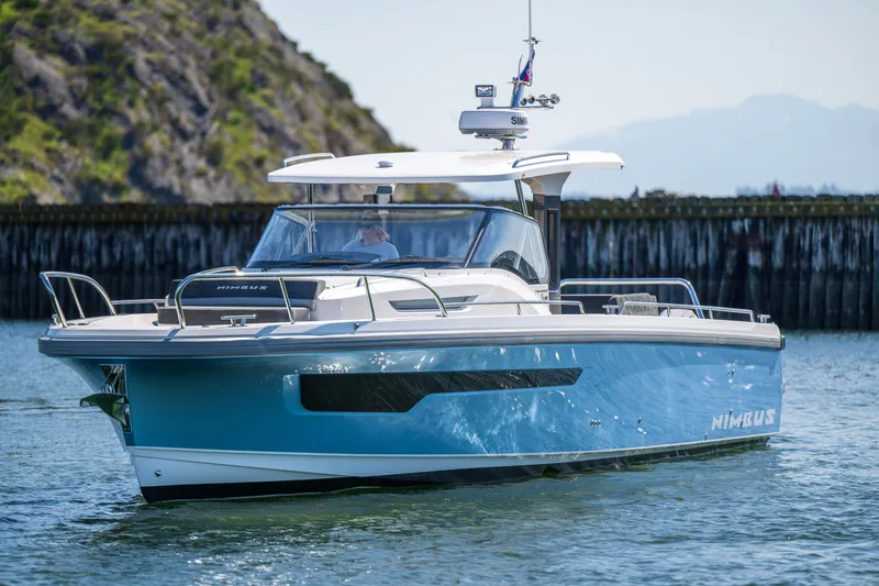 Slide: The Image of 2023 Nimbus Tender 11 boat cruising on calm water near rocky shoreline. - 9