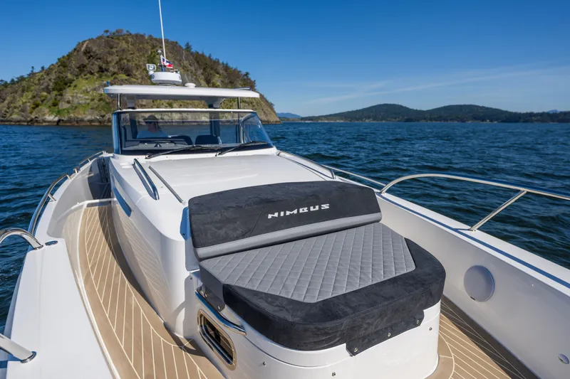 Slide: The Image of 2023 Nimbus Tender 11 boat cruising on a scenic lake with mountainous backdrop. - 6