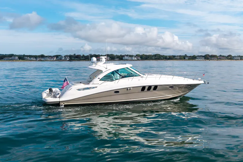 Slide: The Image of 2006 Sea Ray 48 Sundancer yacht cruising on calm waters under a blue sky. - 16