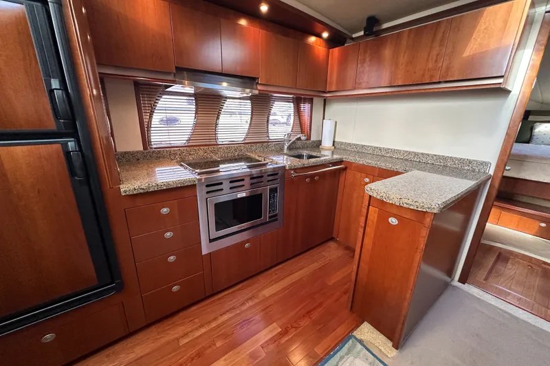 Slide: The Image of Luxurious kitchen interior of 2006 Sea Ray 48 Sundancer yacht with wood cabinetry. - 63