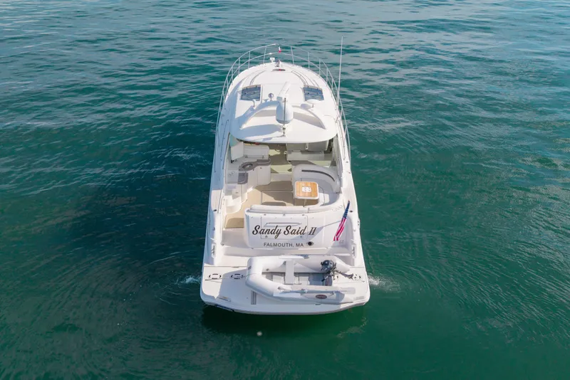 Slide: The Image of 2006 Sea Ray 48 Sundancer yacht on open water, rear view with American flag. - 25