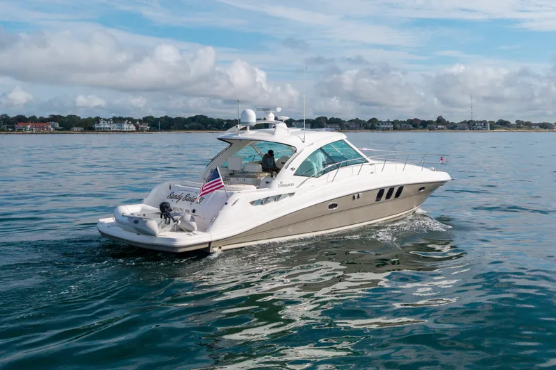 Slide: The Image of 2006 Sea Ray 48 Sundancer yacht cruising on calm waters under a partly cloudy sky. - 17