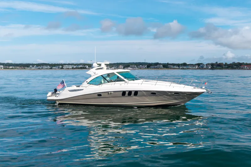 Slide: The Image of 2006 Sea Ray 48 Sundancer yacht cruising on calm waters under a clear sky. - 15
