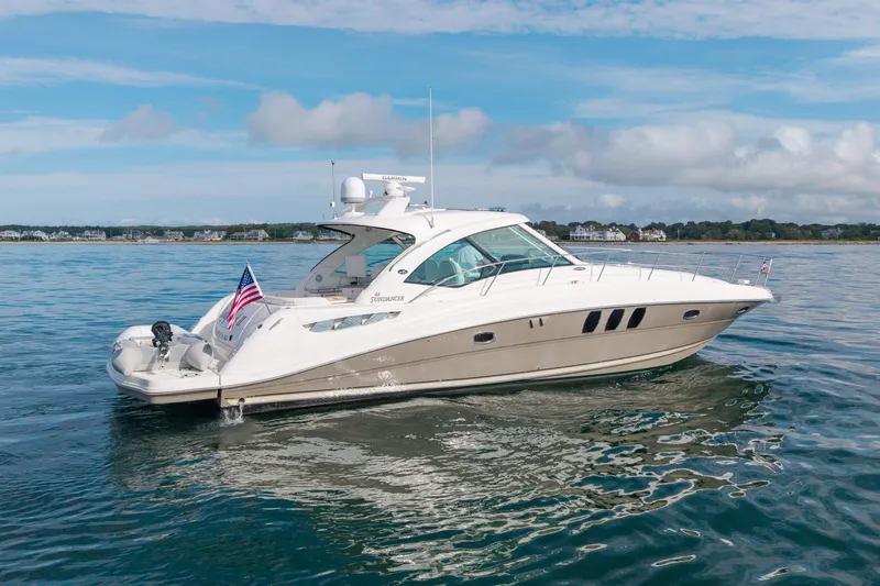 Slide: The Image of 2006 Sea Ray 48 Sundancer yacht cruising on calm waters under a blue sky. - 19