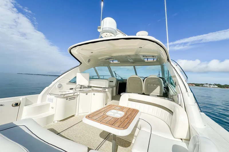 Slide: The Image of 2006 Sea Ray 48 Sundancer yacht with spacious deck and seating, cruising on calm waters. - 39