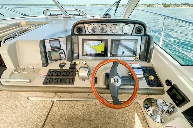 Slide: The Image of Helm of 2006 Sea Ray 48 Sundancer yacht with navigation screens and controls. - 54