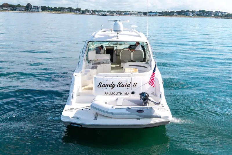 Slide: The Image of 2006 Sea Ray 48 Sundancer yacht on calm waters, rear view with American flag. - 33