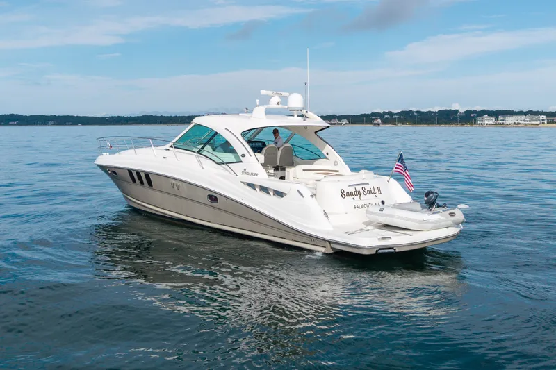 Slide: The Image of 2006 Sea Ray 48 Sundancer yacht on calm water, American flag displayed. - 13