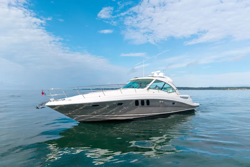 Slide: The Image of 2006 Sea Ray 48 Sundancer yacht cruising on calm waters under a clear blue sky. - 10