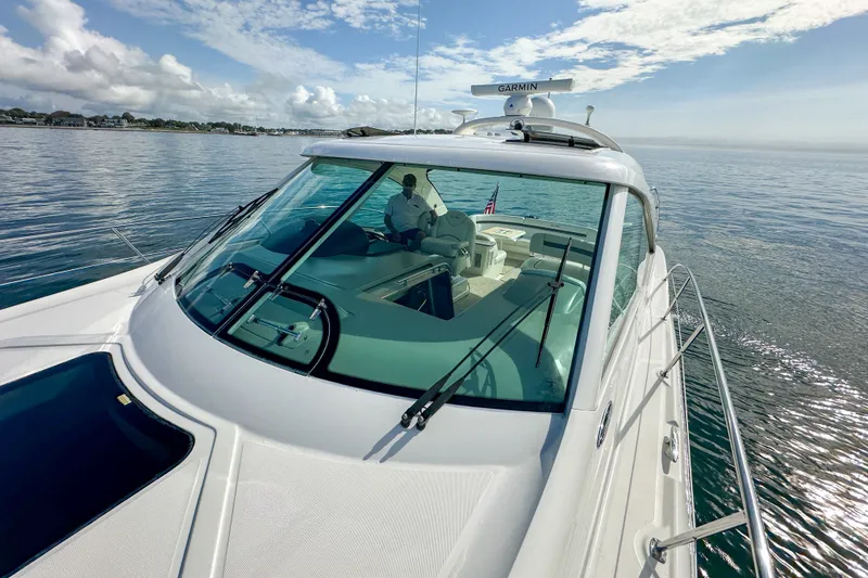 Slide: The Image of 2006 Sea Ray 48 Sundancer yacht cruising on calm waters under a partly cloudy sky. - 61