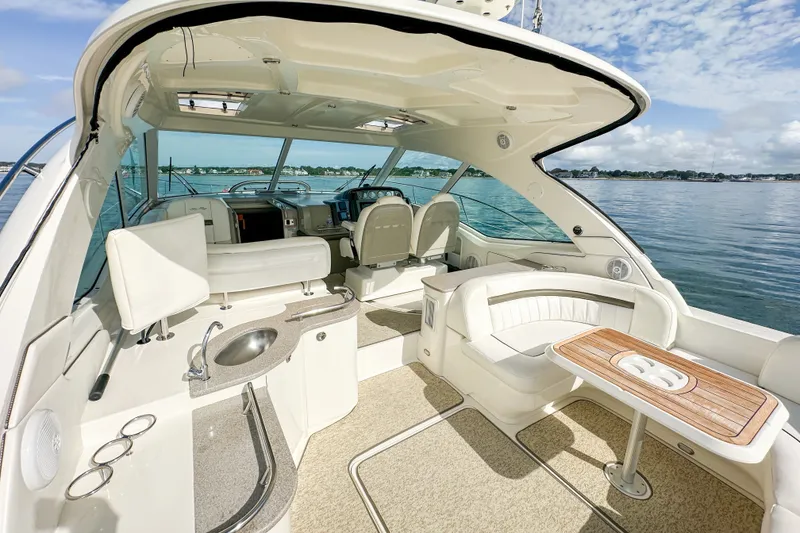 Slide: The Image of Luxurious 2006 Sea Ray 48 Sundancer yacht interior with seating and helm, overlooking serene waters. - 40