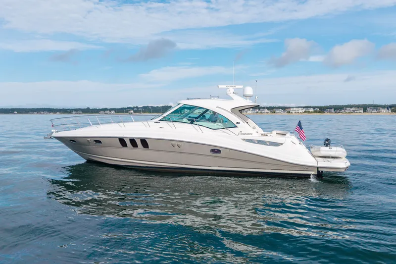 Slide: The Image of 2006 Sea Ray 48 Sundancer yacht on calm water, showcasing sleek design and luxury features. - 6