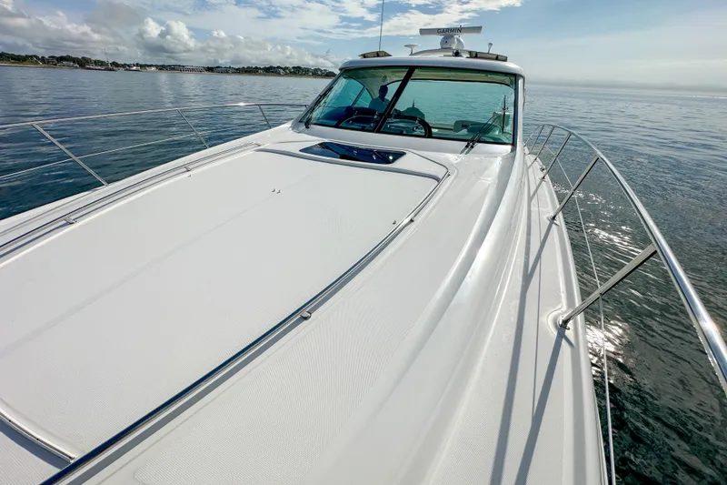 Slide: The Image of 2006 Sea Ray 48 Sundancer yacht cruising on calm waters under a clear sky. - 58