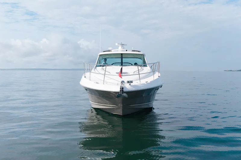 Slide: The Image of 2006 Sea Ray 48 Sundancer yacht on calm water under a cloudy sky. - 23